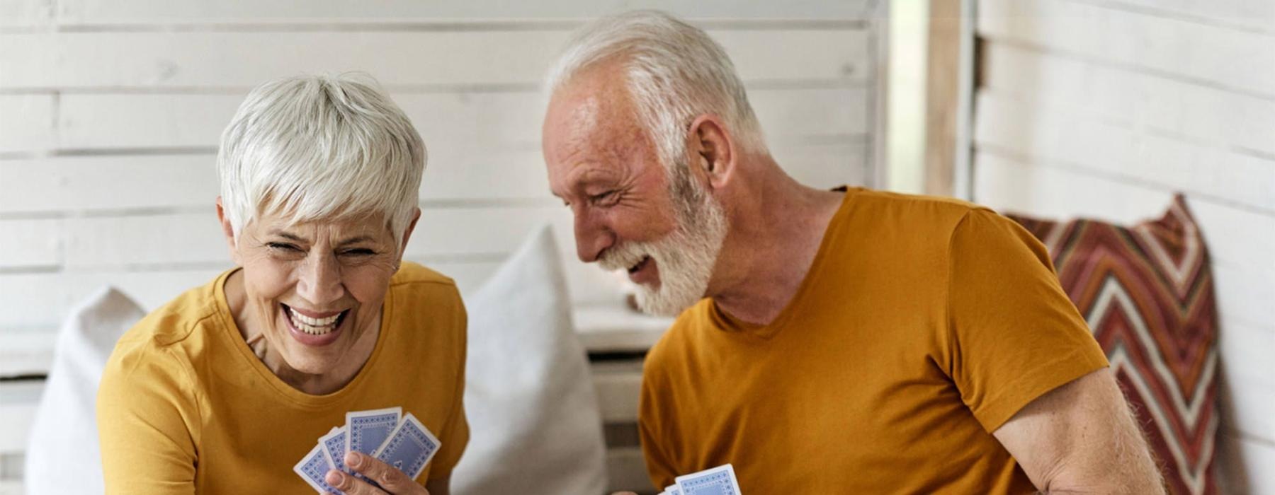 a man and woman sitting at a table playing cards