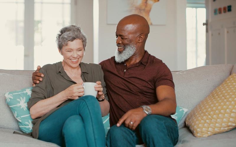 smiling, older couple, sit together on a couch